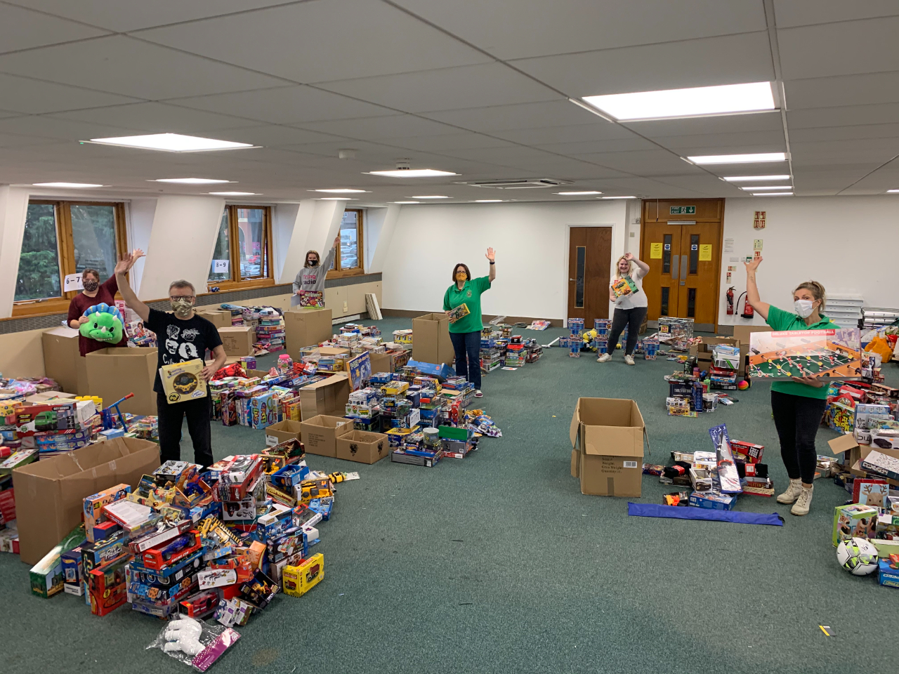 Image of toys and elves sorting through donations